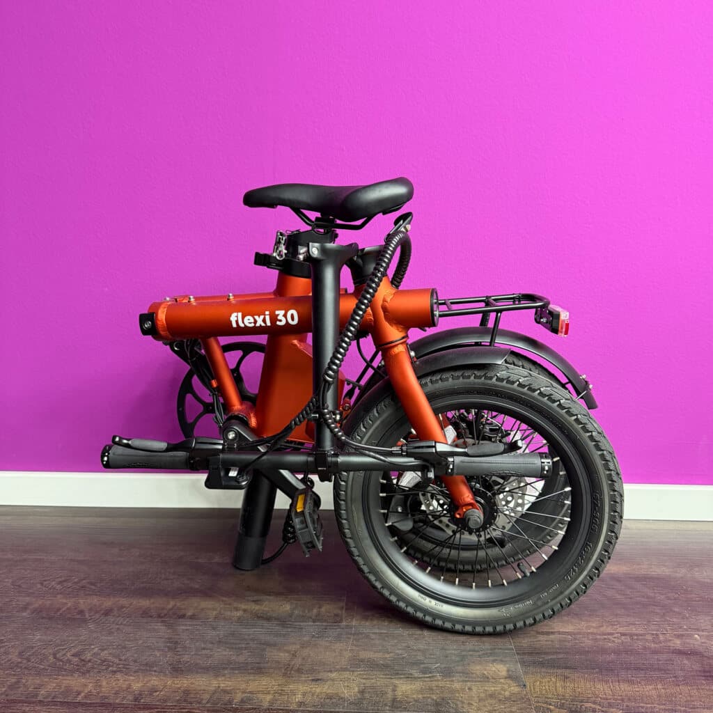 Faltbares Fahrrad vor lila Wand